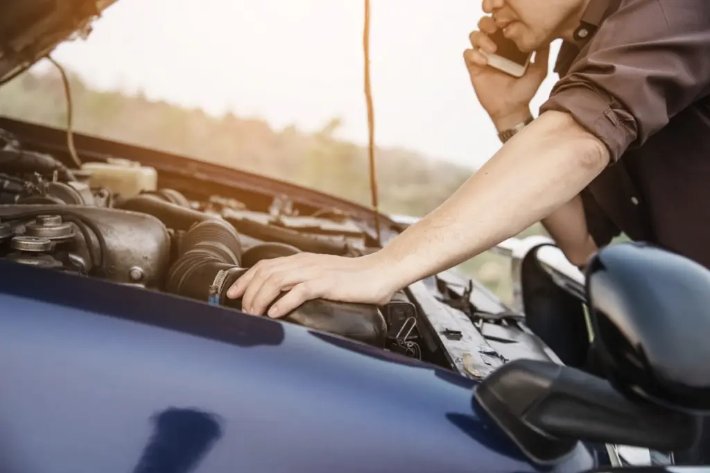 hombre mirando motor del coche