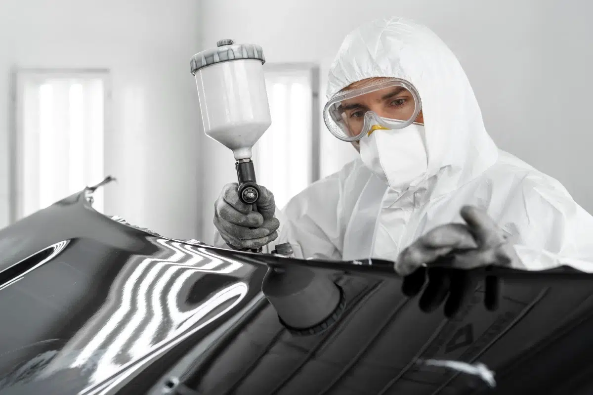 trabajador dando pintura a un coche