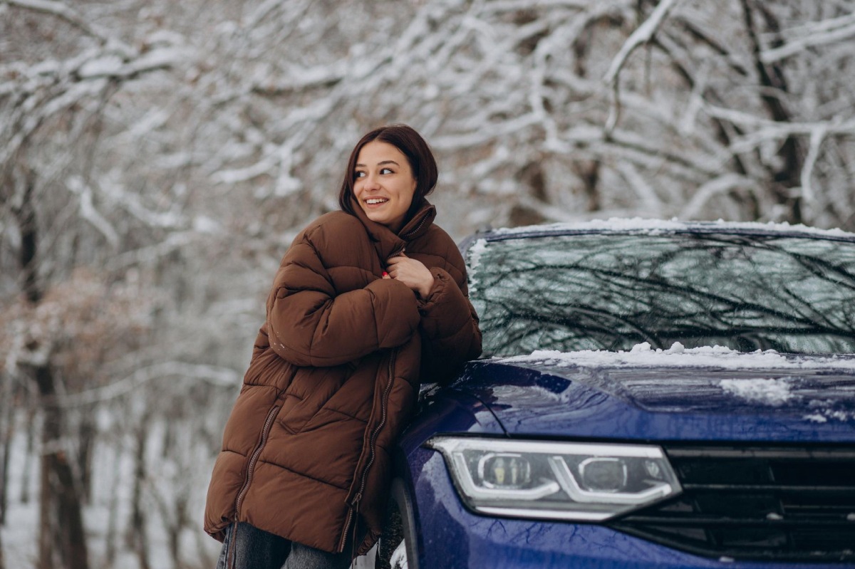mujer al lado del coche en invierno