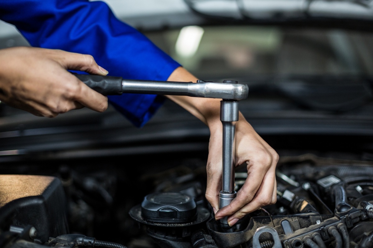 mecanico con llave arreglando coche