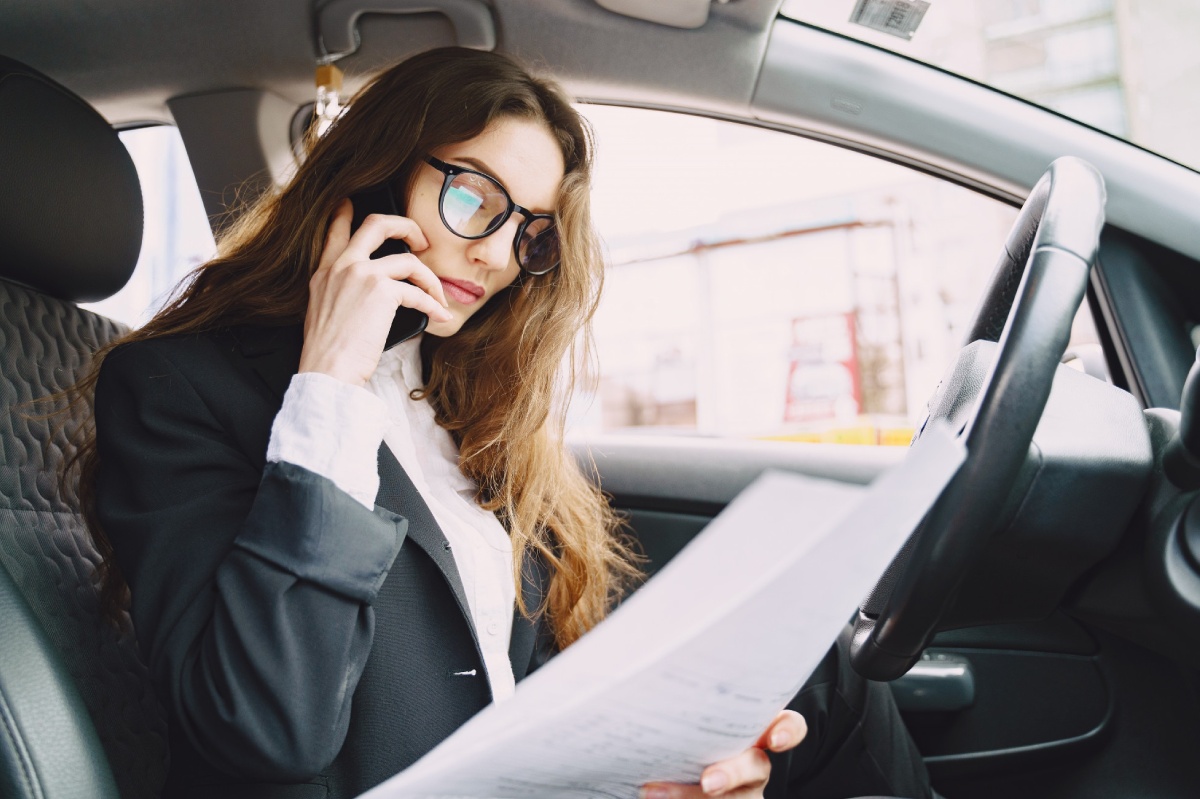 mujer mirando papeles del coche