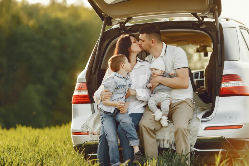 pareja con hijos en coche familiar