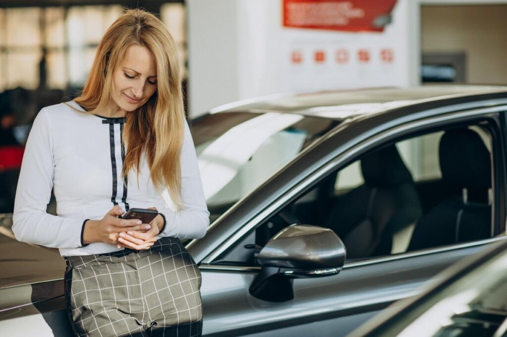 mujer aproyada sobre coche de segunda mano