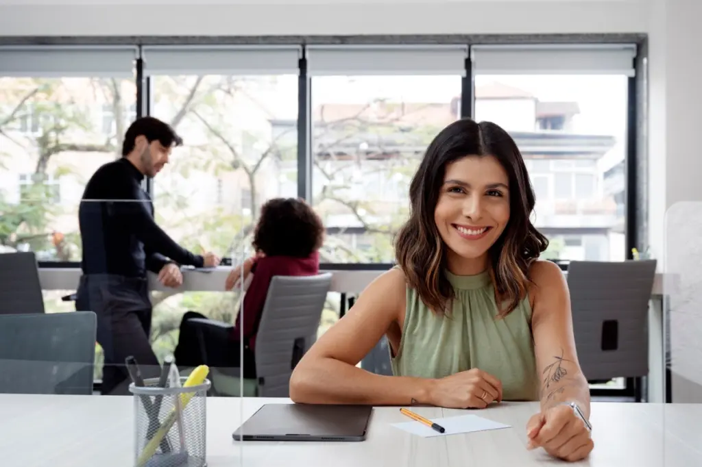oficinista sonriendo sentada en una mesa
