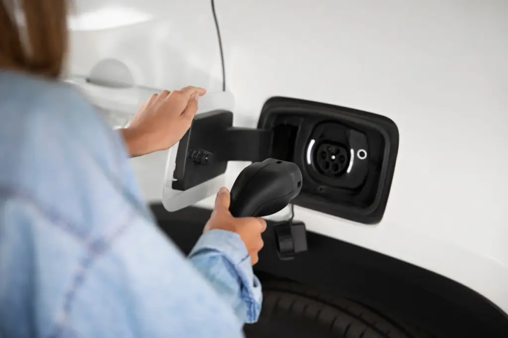 mujer conectando cargador a furgoneta electrica