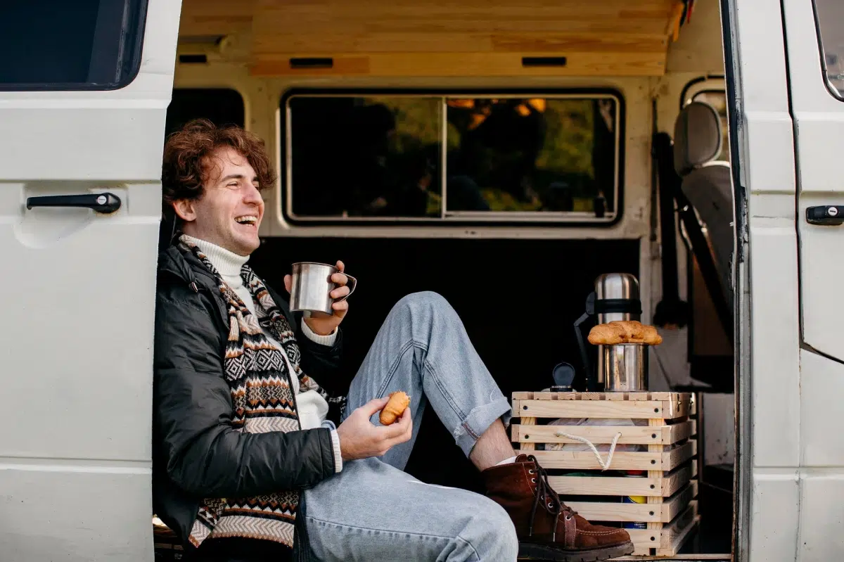 hombre sentado en camper comiendo