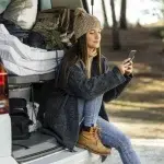 vista lateral mujer sentada maletero camper